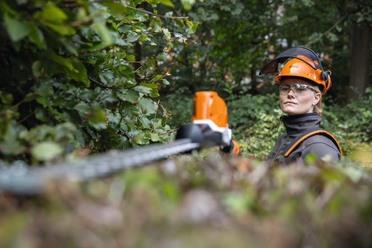 Frau arbeitet mit Stihl HLA 86 teleskopierbarer Heckenschneider