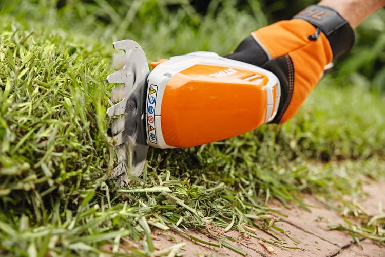 STIHL HSA 26 mit Grasmesser trimmt Rasenkante