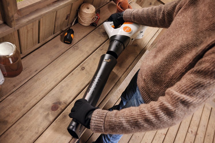 Eine Peson montiert das Blasrohr des STIHL BGA 30 ohne Werkzeuge ab