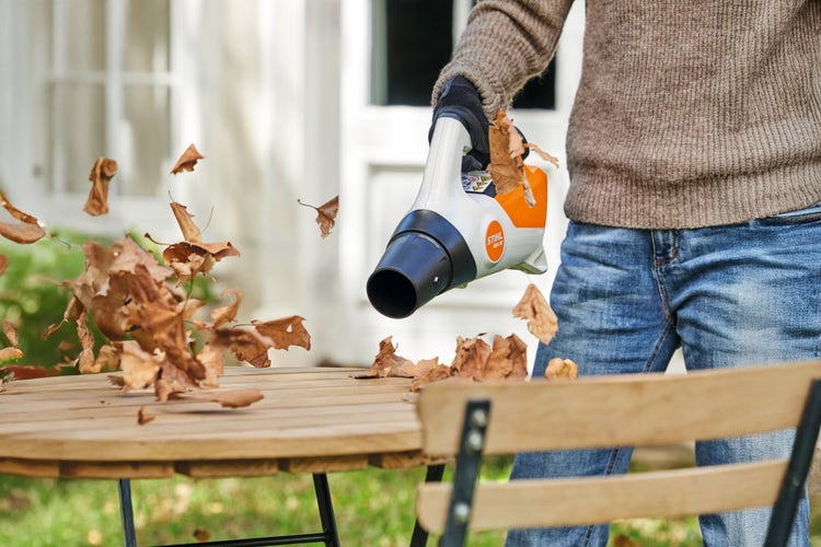 Eine Person entfernt laub von einem Tisch mit dem STIHL BGA 30
