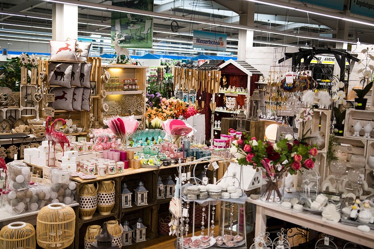 Bild mit Aufsteller für diverse Dekoartikel im Baumarkt, darunter Tassen und Mitbringsel